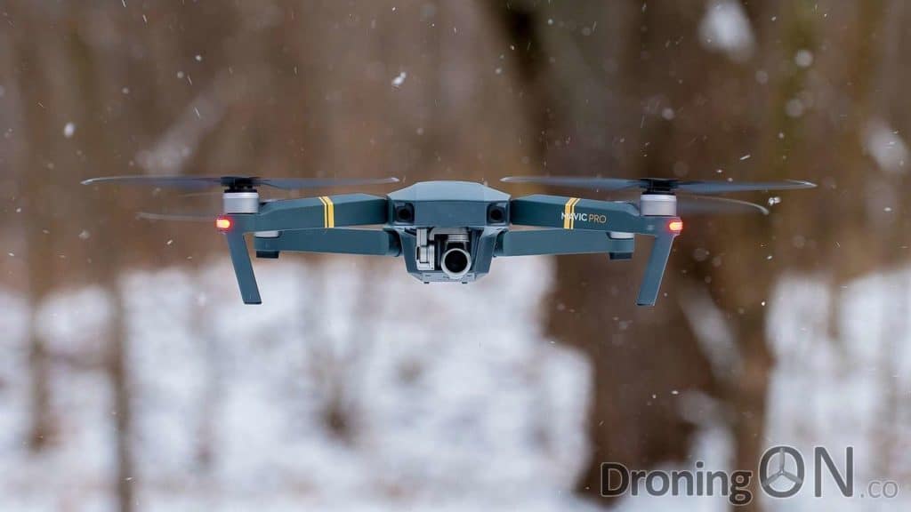 A DJI Mavic Pro hovering on a snowy day.